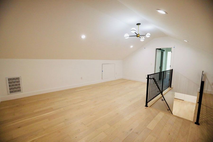 Additional living space with light wood-type flooring and recessed lighting