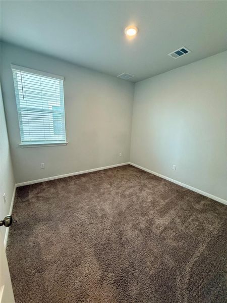 Carpeted room featuring a single window with blinds, recessed ceiling lighting, and light-toned walls