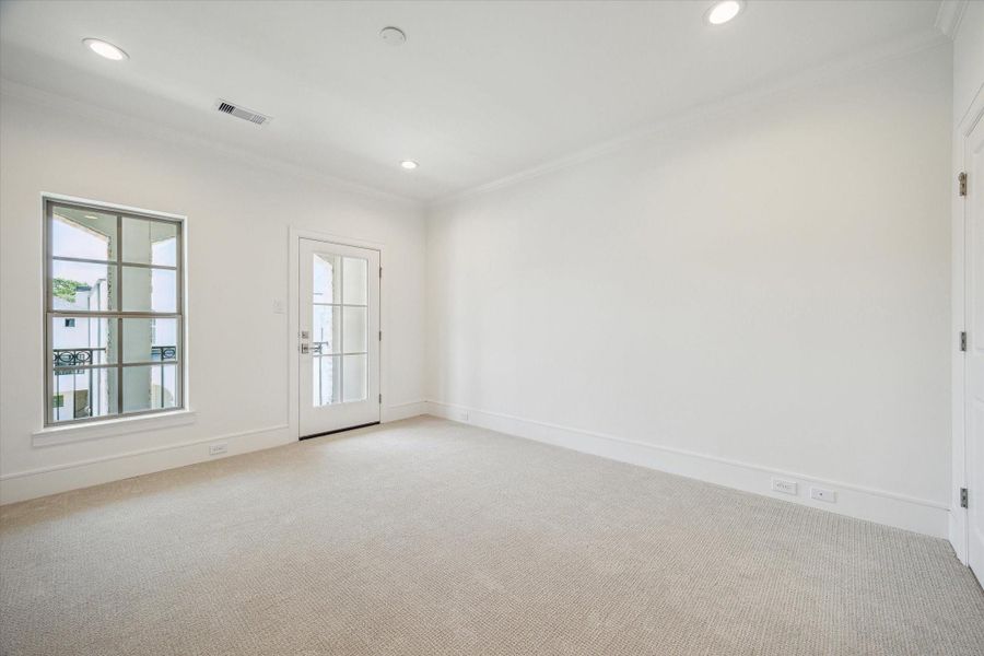 Third-floor Secondary Bedroom with walk-in closet, and glass door for access to balcony.