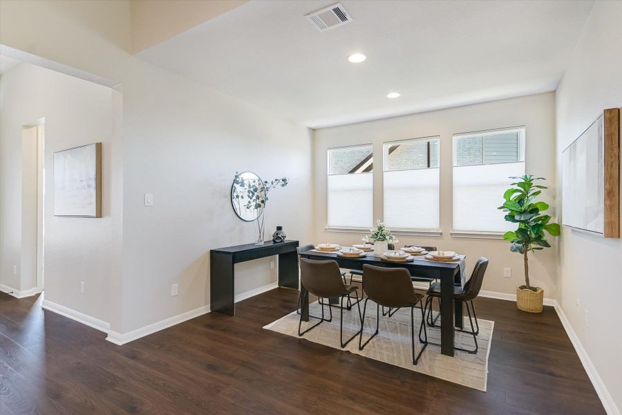 The dining room is located just off the kitchen, featuring custom blinds and beautiful Redwood® flooring.
