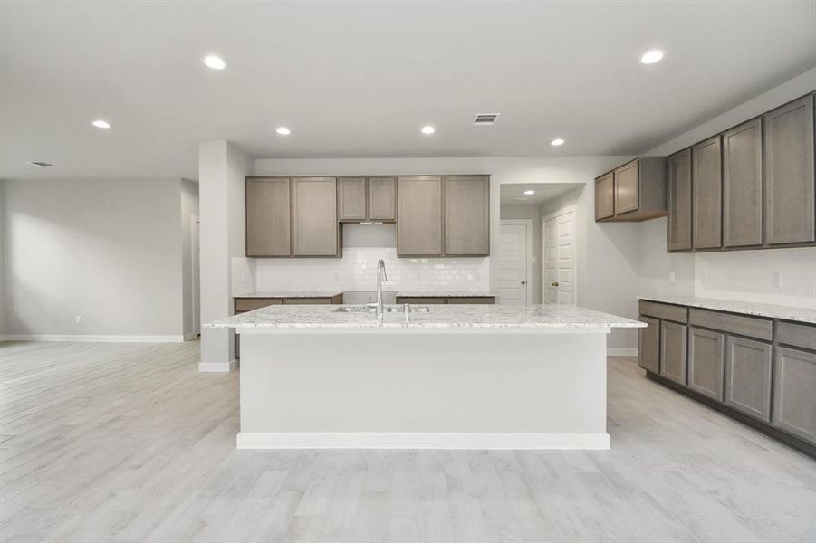 Discover another perspective of this stunning kitchen, generously appointed with an abundance of counter space.