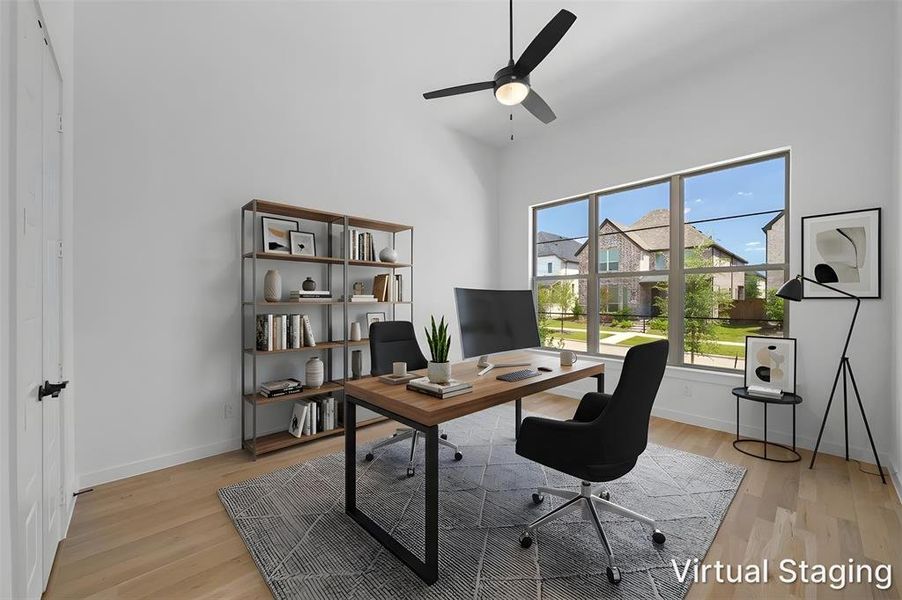 Spacious interior featuring wood-finish flooring, a contemporary ceiling fan, and large windows providing ample natural light. Virtually Staged