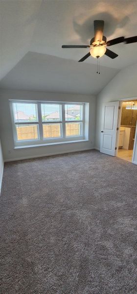 Spare room featuring lofted ceiling, a ceiling fan, and carpet flooring Spare room featuring lofted ceiling, a ceiling fan, and carpet flooring