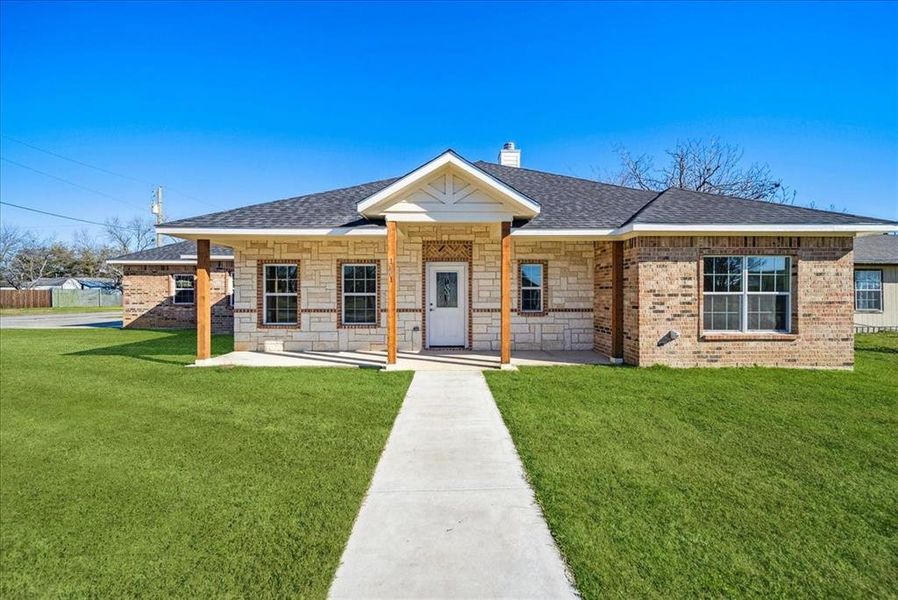 View of front of house featuring covered porch and a front yard