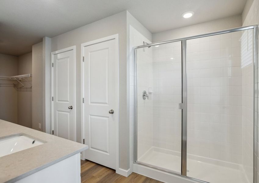 The master bathroom has a dual sink vanity and a step in shower.