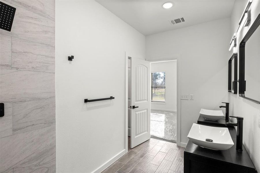 Full bath featuring wood tiled floors and double vanity