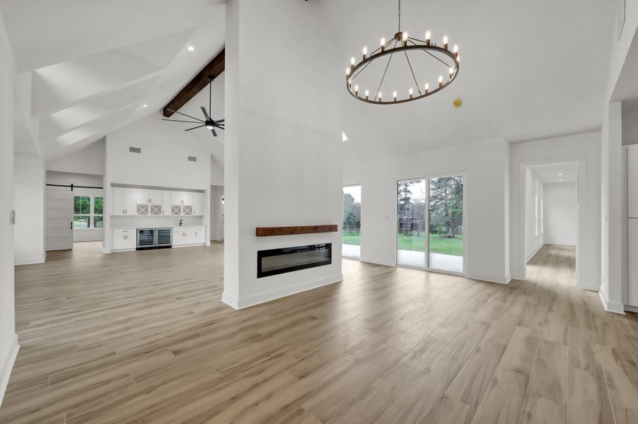 Another view of the main living area emphasizing the dramatic vaulted ceilings and the sleek double-sided fireplace that anchors the room.