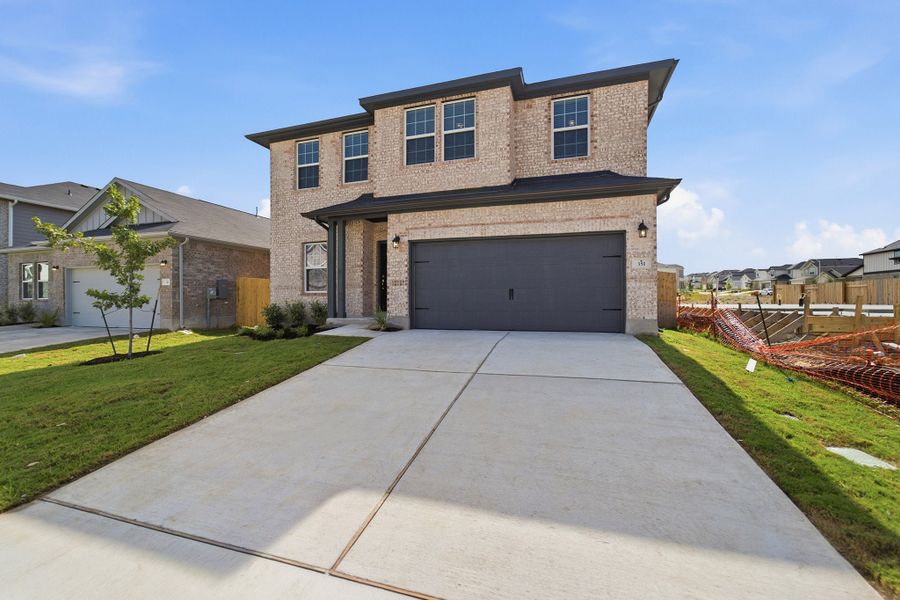 Front exterior of a new home in Sunfield, Buda, TX, highlighting curb appeal (Image 26). Front exterior of a new home in Sunfield, Buda, TX, highlighting curb appeal (Image 26).