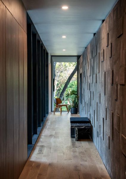 Corridor with expansive windows and builder's signature volcanic rock wall.