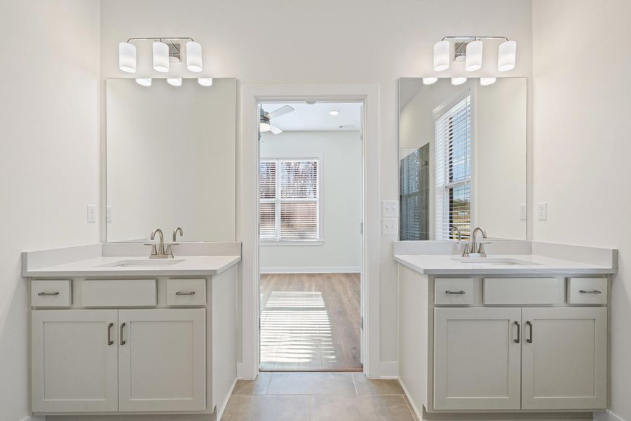 Full bathroom featuring two vanities, light tile patterned floors, and ceiling fan