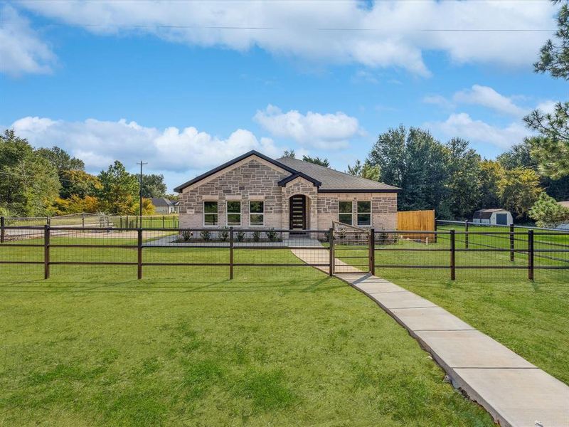 View of front of home featuring stone siding, brick siding, and a rural view