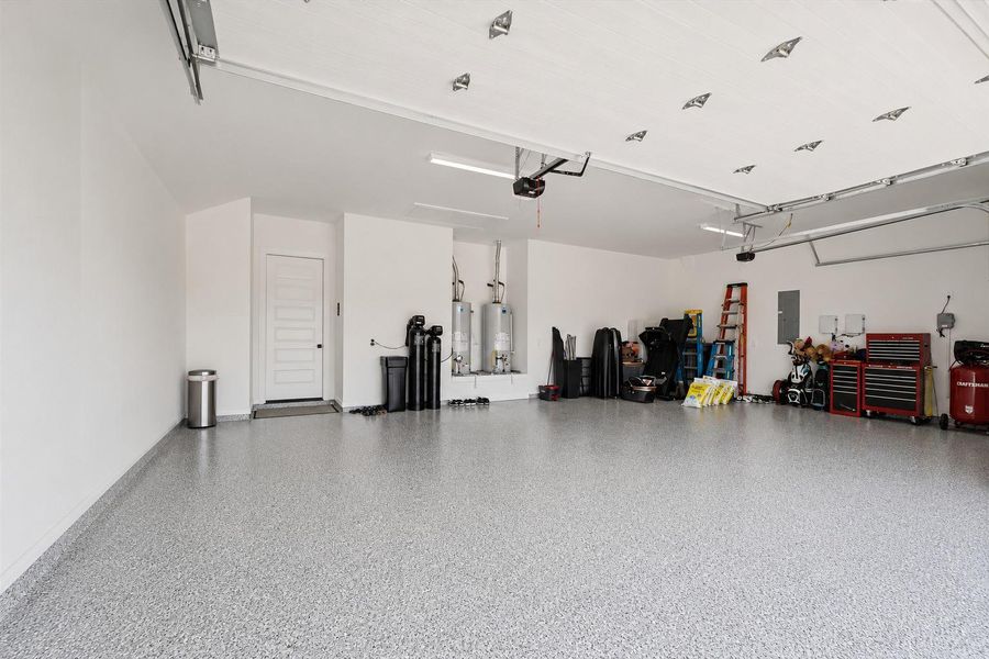 The oversized garage features professionally finished epoxy flooring, creating a polished and durable space ideal for storage, hobbies, workouts, or showcasing vehicles. Clean lines, high ceilings, and upgraded finishes elevate this garage far beyond standard functionality.