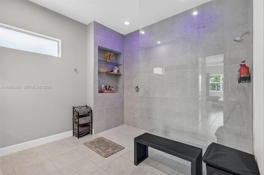 Spa inspired primary bathroom with ceiling-to-floor shower LED lighting, customizable to set the perfect atmosphere.