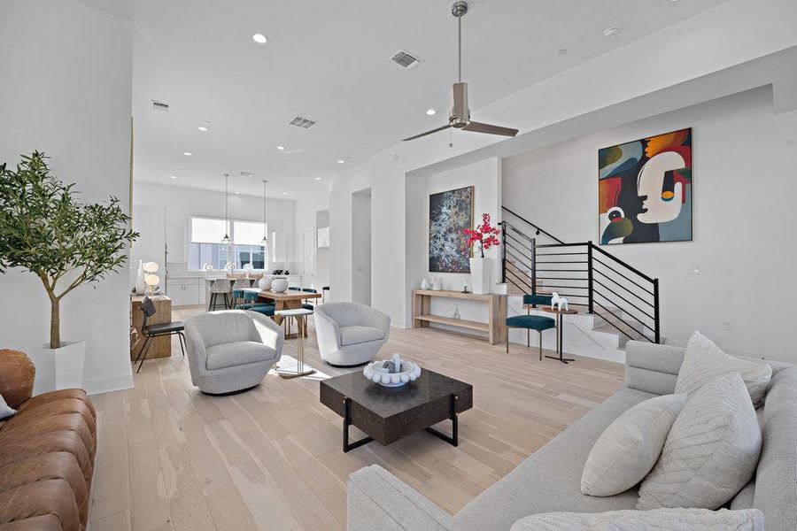 Living area featuring light wood finished floors, stairs, recessed lighting, and ceiling fan