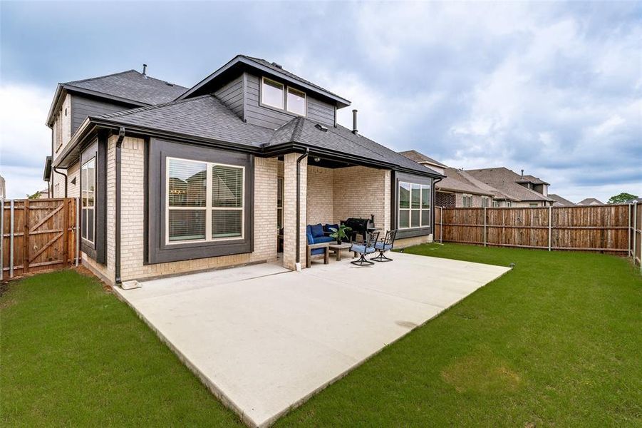 Expansive concrete patio extending from the property, complemented by a covered outdoor living area