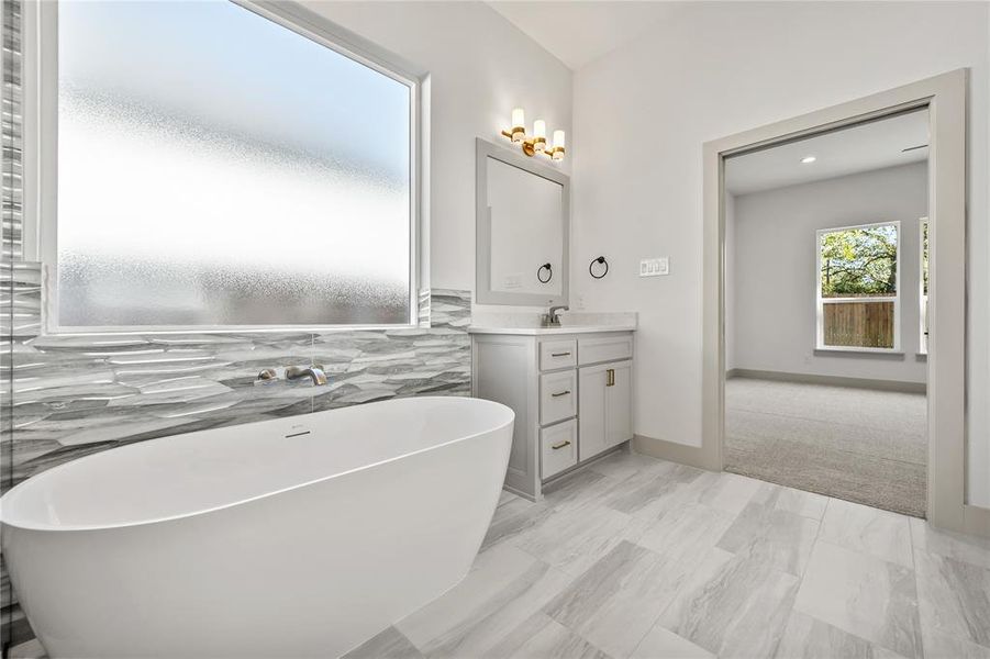 Full bathroom featuring a freestanding bath and vanity