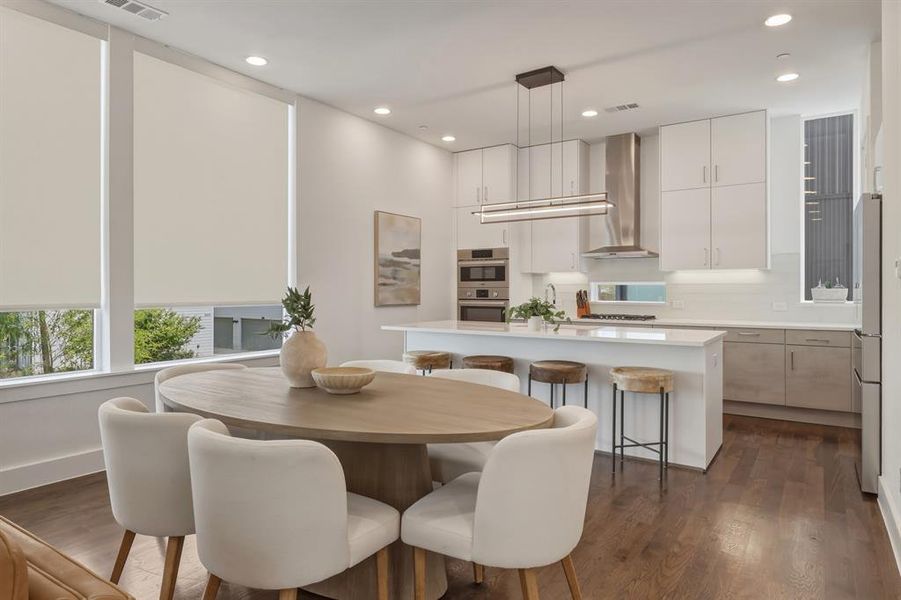 Dining room with dark wood finished floors and recessed lighting