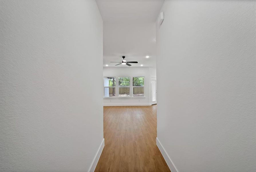 Hall with light wood-style flooring and baseboards