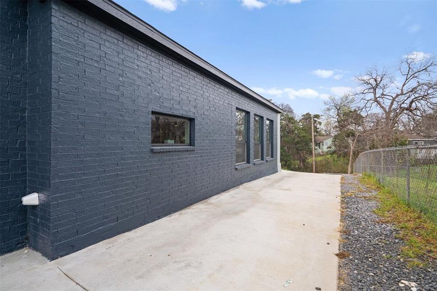 View of side of home featuring a patio area and brick siding View of side of home featuring a patio area and brick siding