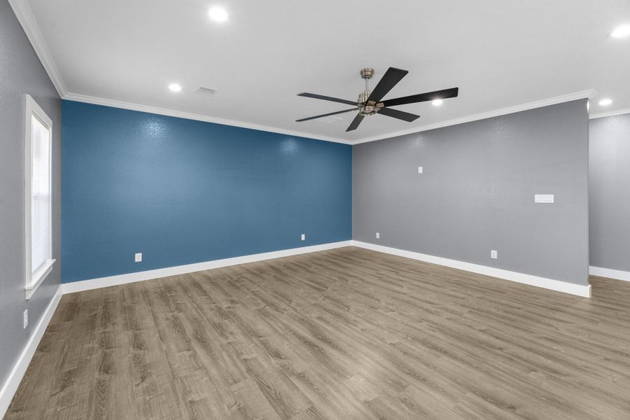 Living room has an accent wall. Large, modern ceiling fans throughout the home.