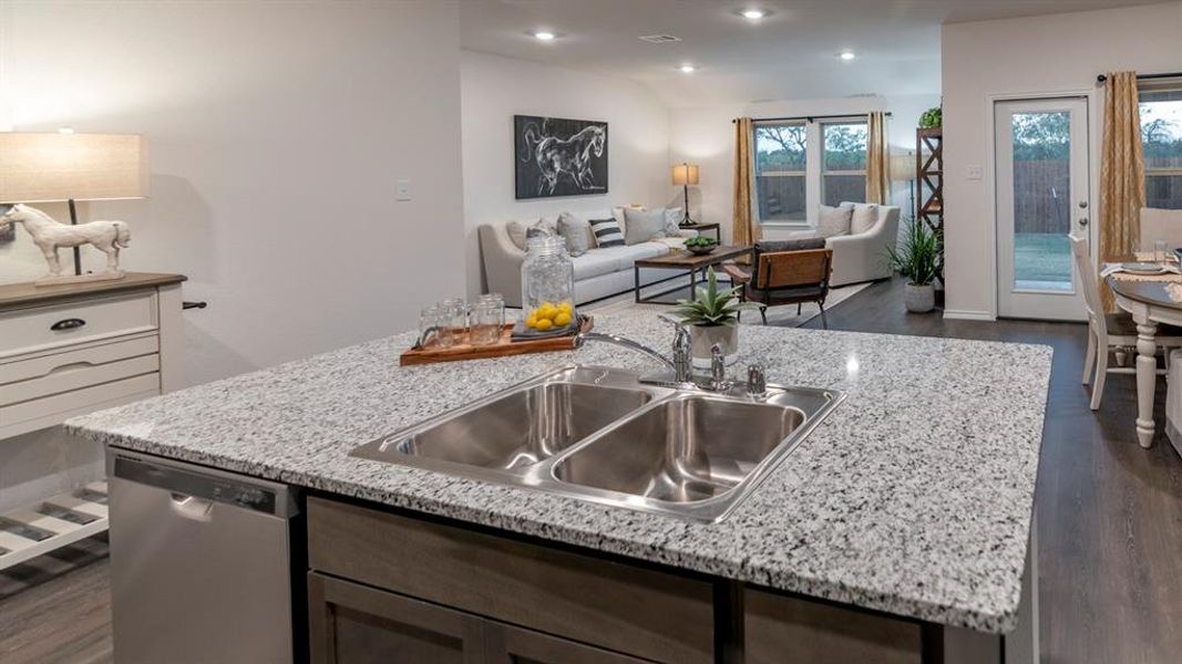 Kitchen with dark wood-type flooring, an island with sink, open floor plan, stainless steel dishwasher, and recessed lighting