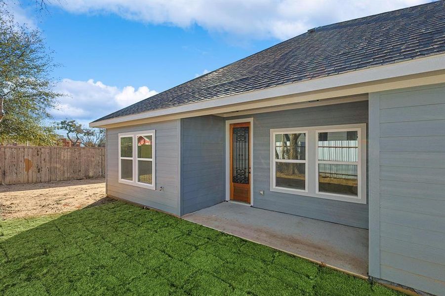 Entrance to property with a patio and a lawn