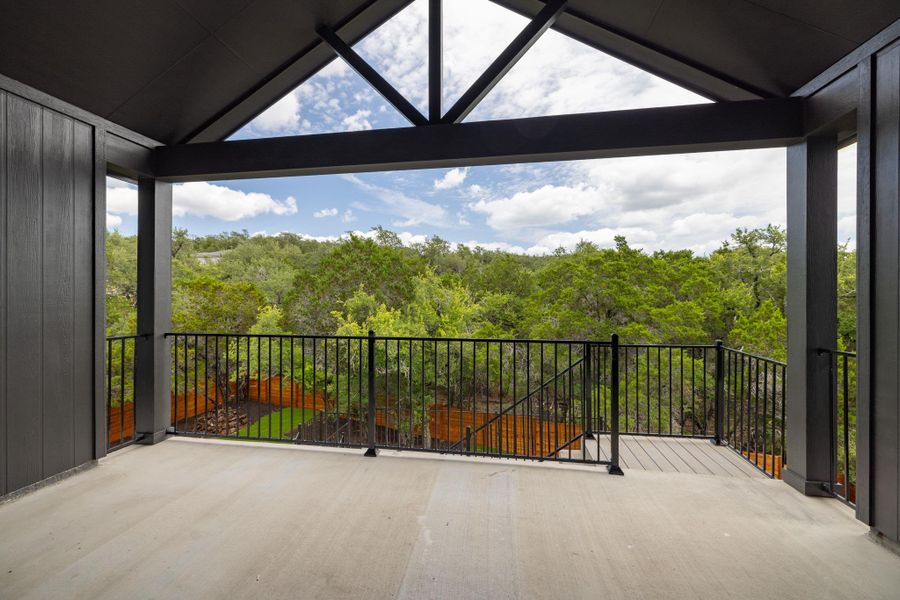 Experience tranquil views from this covered patio, overlooking a lush, verdant landscape.