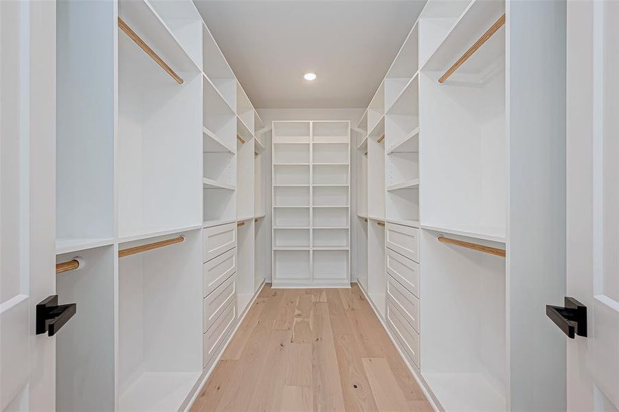 Spacious walk-in closet with ample shelving, hanging space, and drawers.