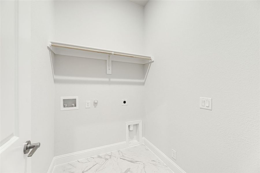 Laundry room with wall-mounted shelf, washer and dryer hookups, and marble tile flooring Laundry room with wall-mounted shelf, washer and dryer hookups, and marble tile flooring