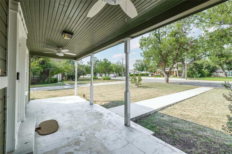 Covered porch featuring a ceiling fan and a lawn Covered porch featuring a ceiling fan and a lawn