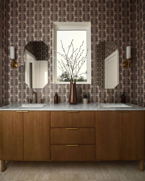 A refined bathroom vanity featuring twin sinks, elegant mirrors, and unique fluted wooden cabinetry under a bright window. A refined bathroom vanity featuring twin sinks, elegant mirrors, and unique fluted wooden cabinetry under a bright window.