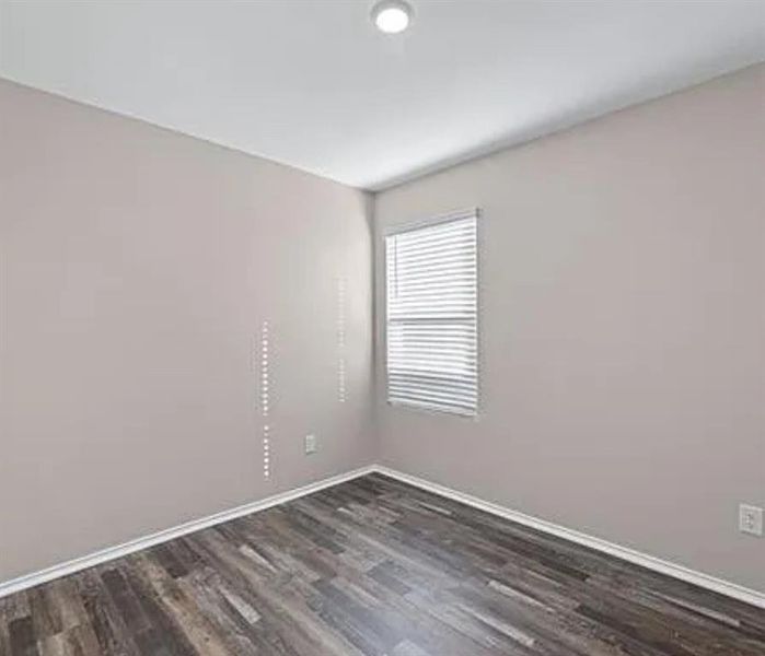 Spare room featuring dark wood-style floors