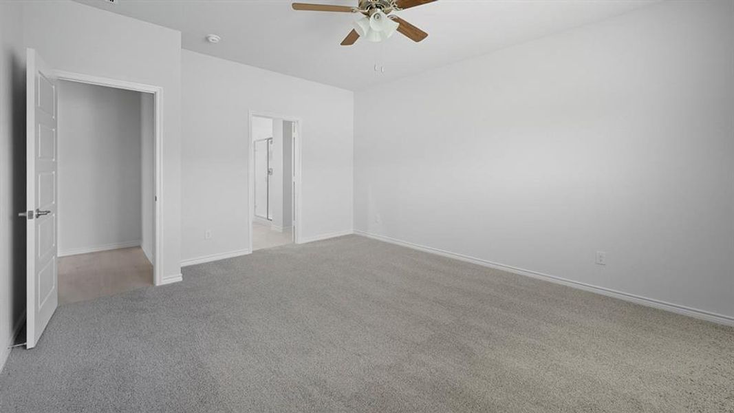 Unfurnished bedroom with light colored carpet, a ceiling fan, and ensuite bath