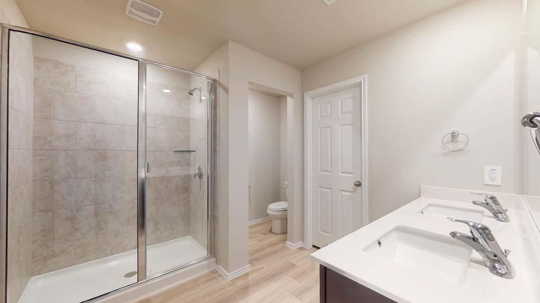 Bathroom featuring a glass-enclosed shower with tiled walls and a built-in shelf