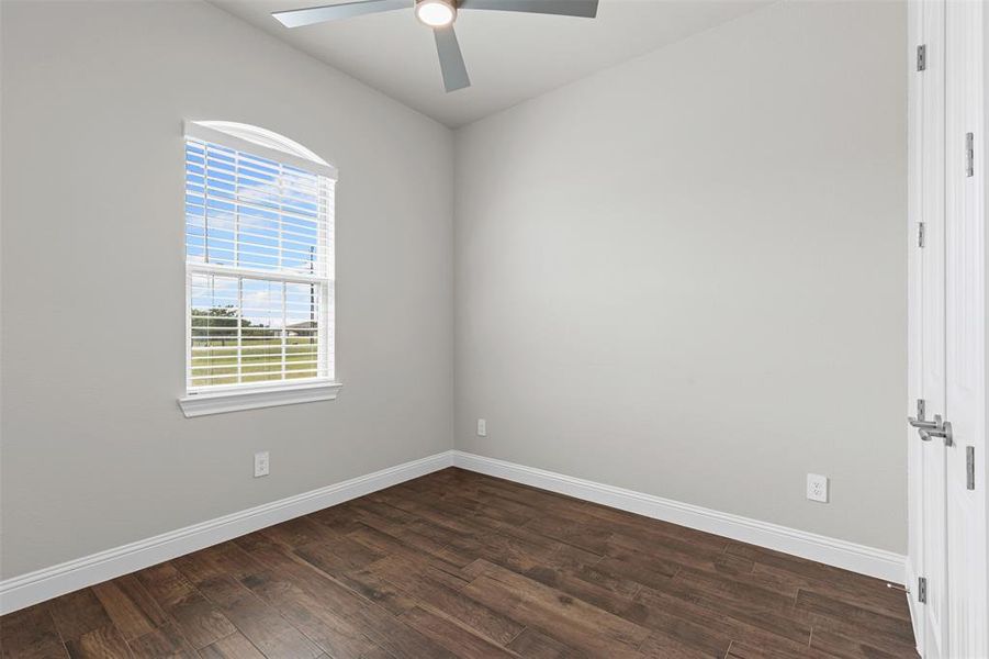Bedroom with dark wood finished floors and a ceiling fan Bedroom with dark wood finished floors and a ceiling fan