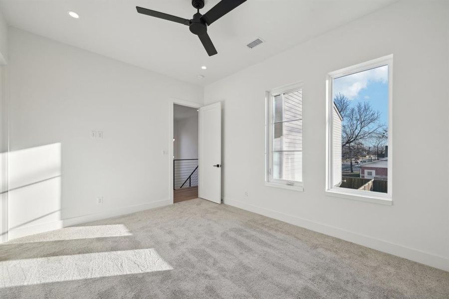 Unfurnished bedroom featuring ceiling fan and light colored carpet