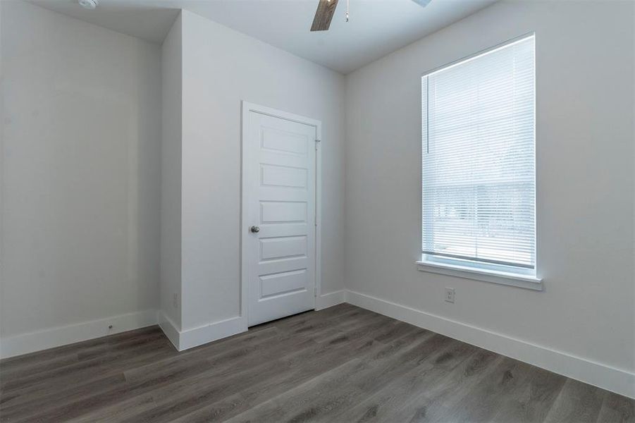 Spare room with ceiling fan and dark wood-type flooring