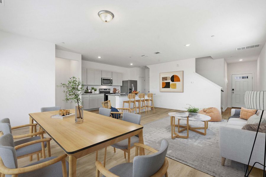 Open-concept living space featuring wood-finish flooring, recessed lighting, and a neutral color palette Open-concept living space featuring wood-finish flooring, recessed lighting, and a neutral color palette