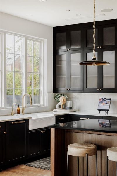 Open to the living space, the kitchen’s farmhouse-style sink creates a seamless flow between cooking, dining, and social connection. Open to the living space, the kitchen’s farmhouse-style sink creates a seamless flow between cooking, dining, and social connection.