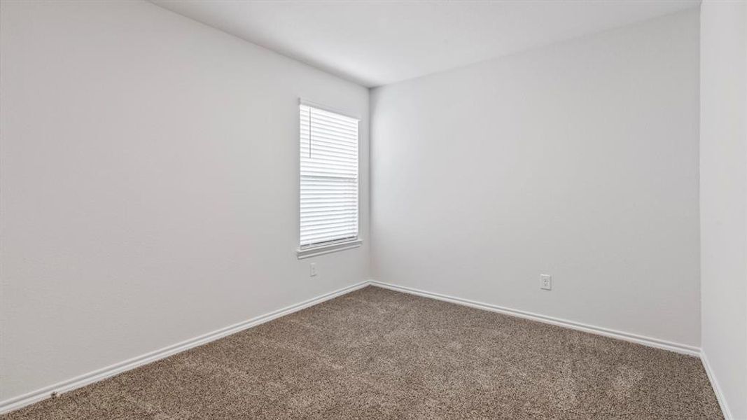 Empty room with baseboards and dark carpet