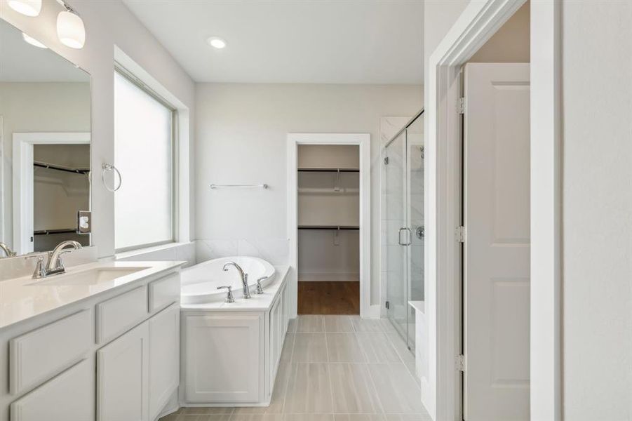 Bathroom with tile patterned flooring, vanity, and independent shower and bath