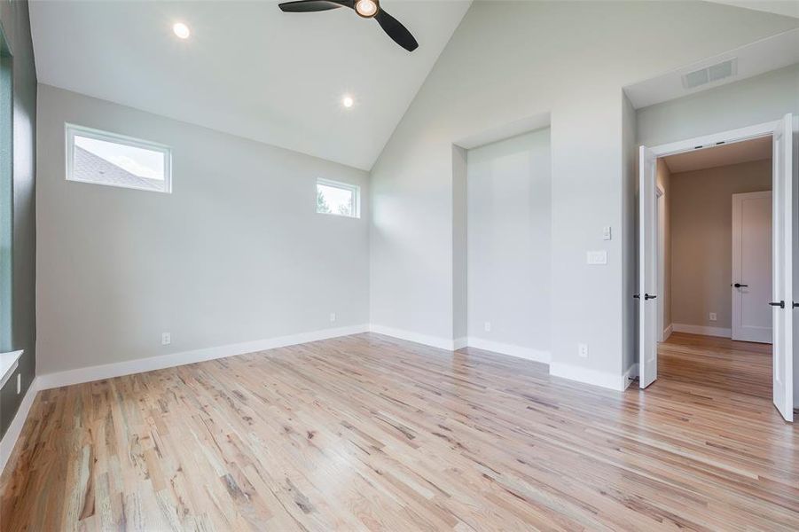 Unfurnished bedroom with light wood-style flooring, high vaulted ceiling, a ceiling fan, and recessed lighting