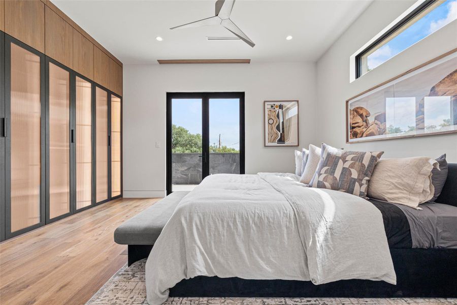 Wood-finish flooring paired with built-in cabinetry featuring wood paneling and translucent glass doors