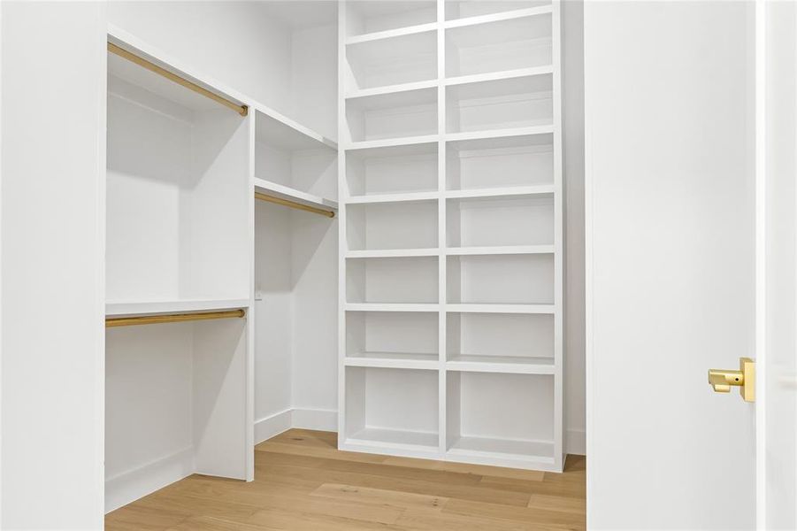 Spacious closet with hardwood / wood-style flooring