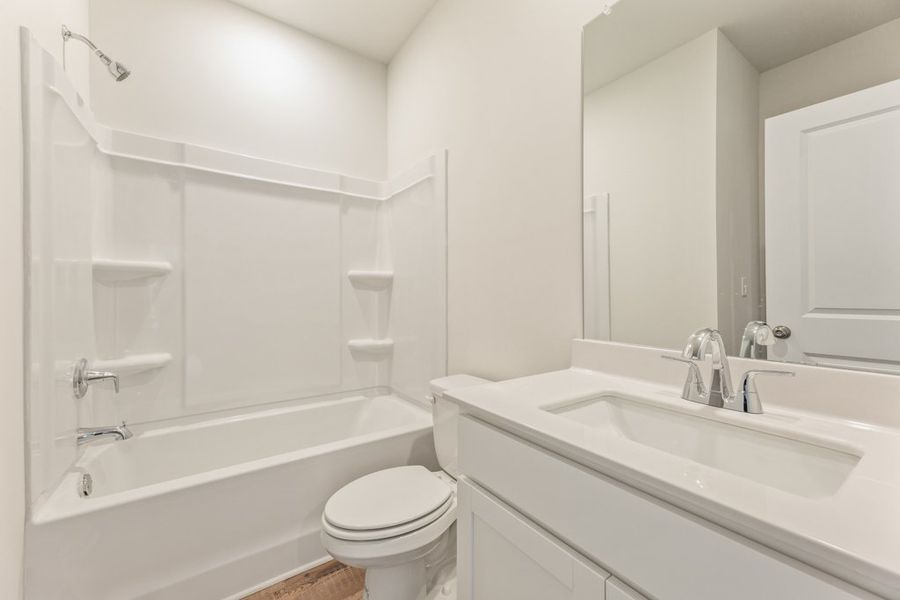 A bathroom with a tub sink and toilet.