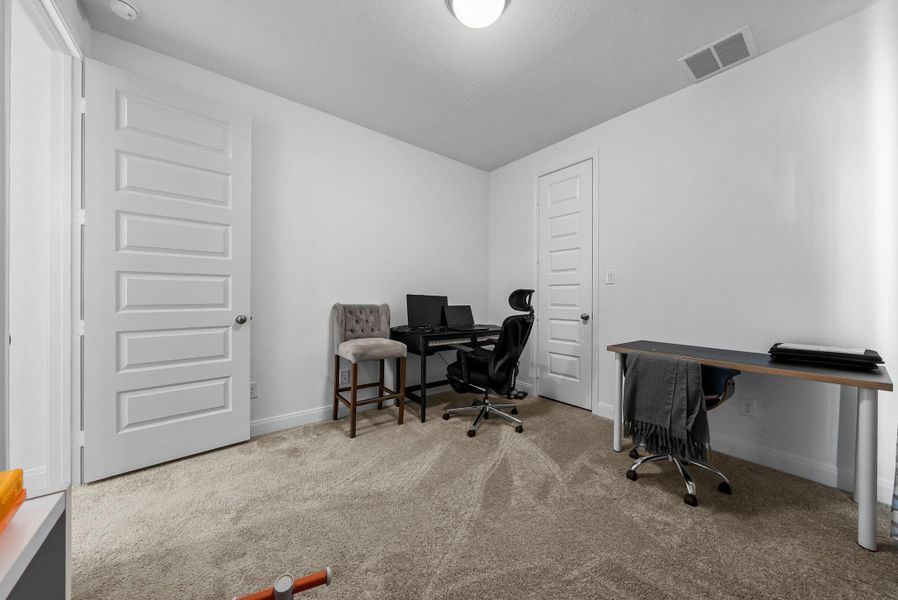 Home office with light carpet and baseboards