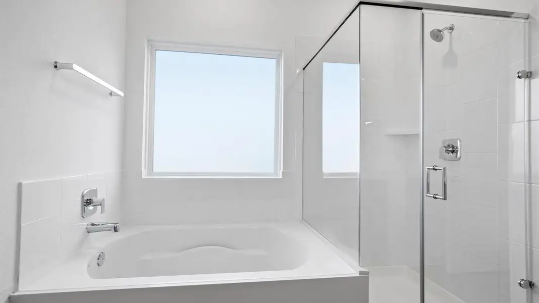 Primary bathroom with a glass-enclosed standing shower and separate soaking tub. Primary bathroom with a glass-enclosed standing shower and separate soaking tub.