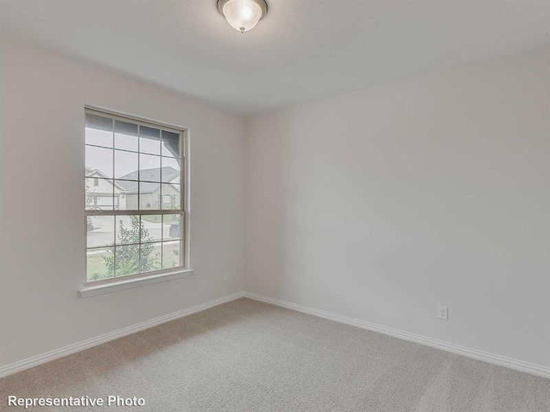 Spare room featuring baseboards and light carpet