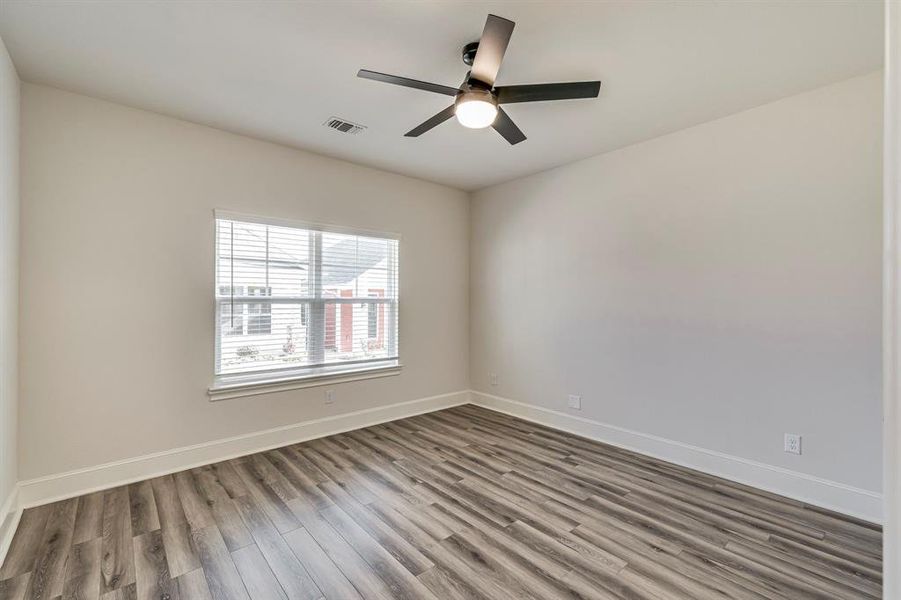 Spare room featuring wood finished floors and a ceiling fan Spare room featuring wood finished floors and a ceiling fan