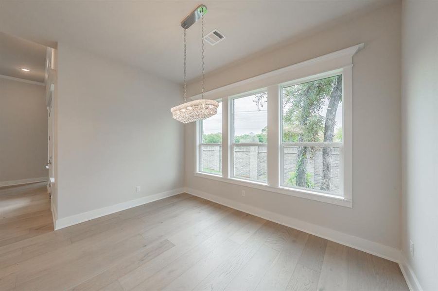 Unfurnished dining area with light wood-style floors, a chandelier, recessed lighting, and ornamental molding
